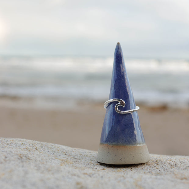 Blue ceramic cone with a silver wave ring on a beach