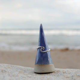Blue ceramic cone with a silver wave ring beach in background